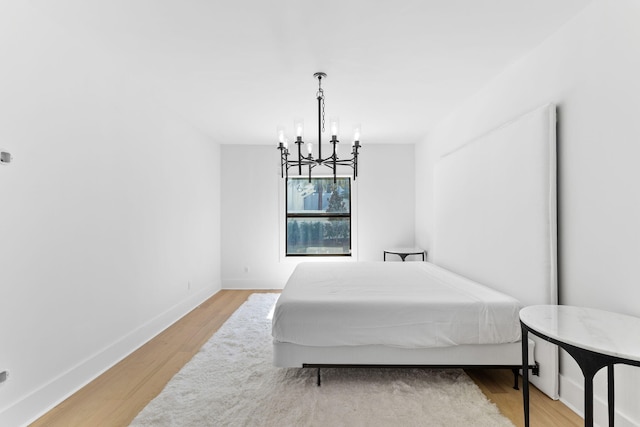 bedroom with a chandelier and wood-type flooring