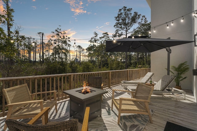 deck at dusk with a fire pit