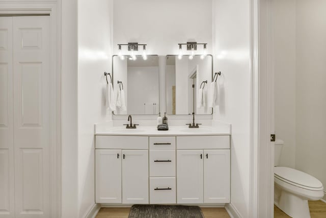 bathroom featuring vanity, wood-type flooring, and toilet