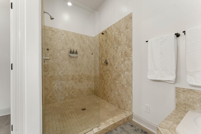 bathroom with tiled shower and tile patterned floors