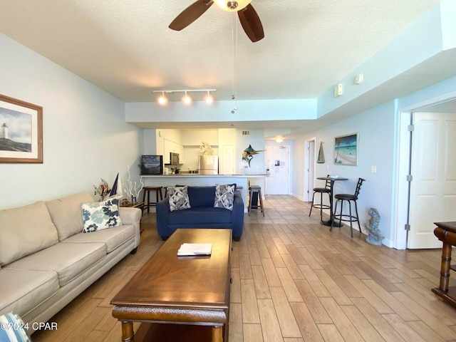 living room with ceiling fan, hardwood / wood-style floors, rail lighting, and a textured ceiling