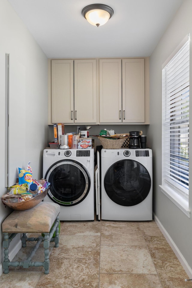 clothes washing area with cabinets and washer and dryer