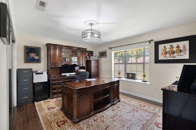 office with dark hardwood / wood-style flooring and a chandelier