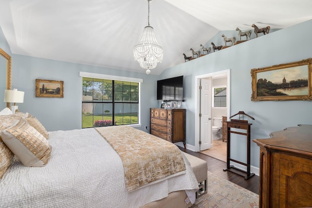 bedroom with an inviting chandelier, ensuite bathroom, vaulted ceiling, and hardwood / wood-style floors