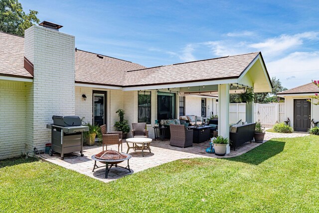 rear view of house featuring a yard, a patio, and an outdoor living space with a fire pit