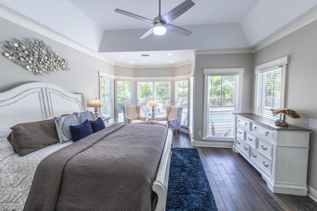 bedroom with a tray ceiling, dark wood-style flooring, crown molding, and baseboards