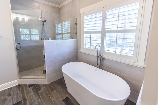 full bathroom with a freestanding tub, a shower stall, tile walls, and wood tiled floor