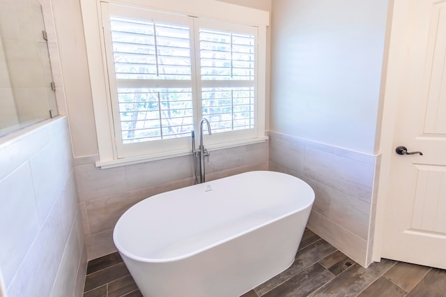 bathroom featuring tile walls and a bath