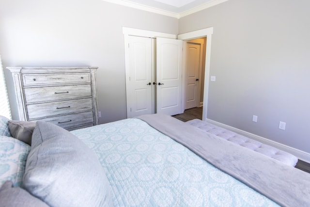 bedroom with baseboards, ornamental molding, and wood finished floors