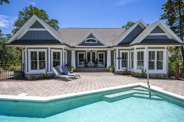 rear view of house featuring a patio and a fenced in pool