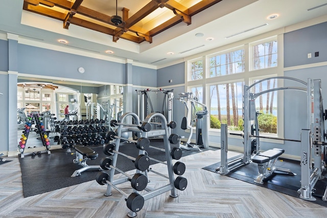 exercise room featuring a high ceiling, visible vents, and baseboards