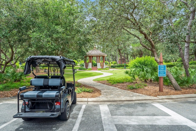 view of vehicle parking with a gazebo and a lawn