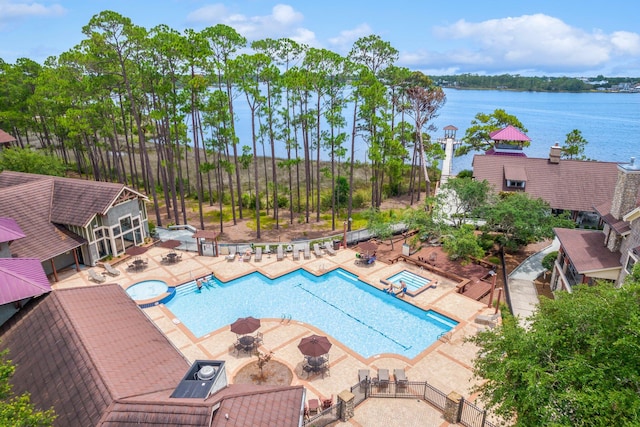 view of pool featuring a water view and a patio