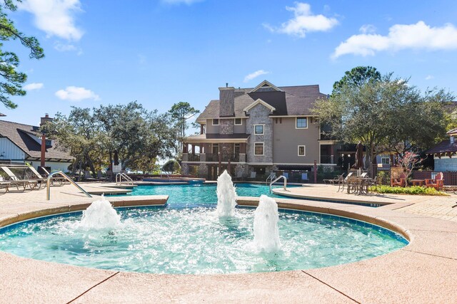 view of pool with a patio area and pool water feature