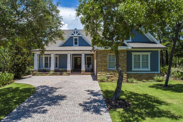 view of front of home featuring covered porch and a front lawn