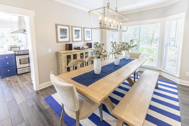 dining area featuring crown molding, a notable chandelier, dark wood finished floors, and baseboards