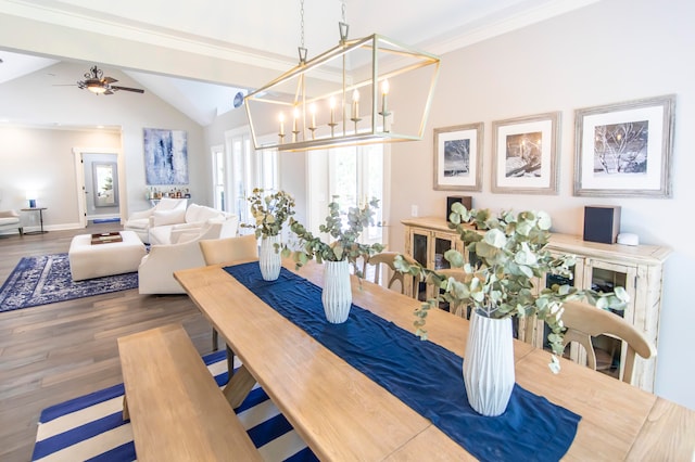 dining space featuring ceiling fan with notable chandelier, vaulted ceiling with beams, and wood-type flooring