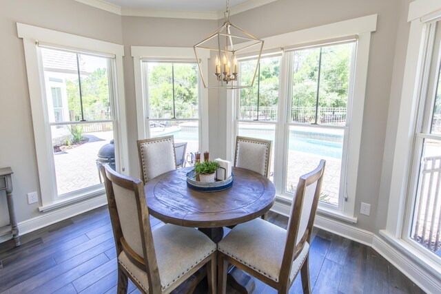 dining area featuring ornamental molding, dark hardwood / wood-style flooring, and a chandelier