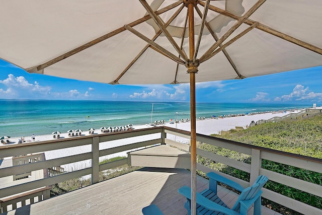 balcony featuring a view of the beach and a water view