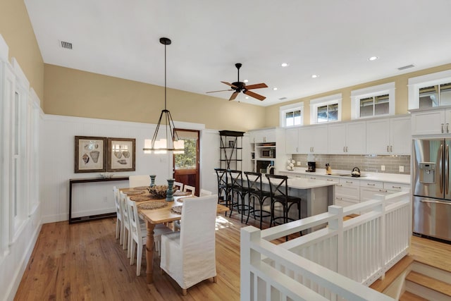 dining room with ceiling fan and light wood-type flooring