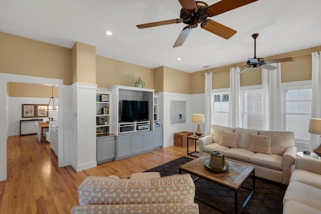 living room with ceiling fan and light wood-type flooring