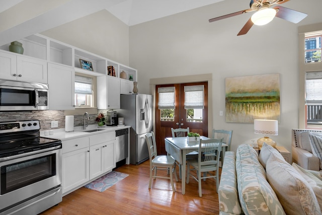 kitchen with appliances with stainless steel finishes, white cabinetry, french doors, and sink