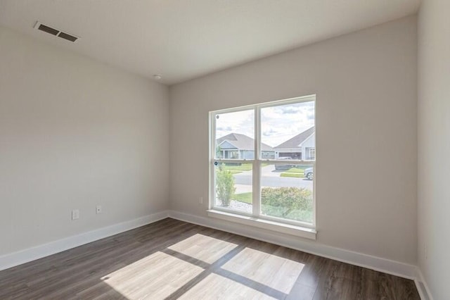 empty room with dark hardwood / wood-style flooring