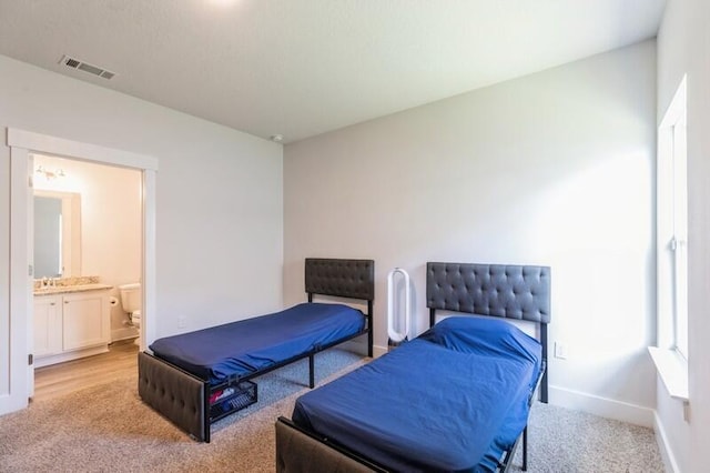 carpeted bedroom with ensuite bathroom