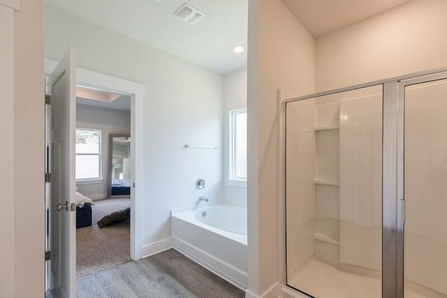 bathroom featuring shower with separate bathtub and hardwood / wood-style floors