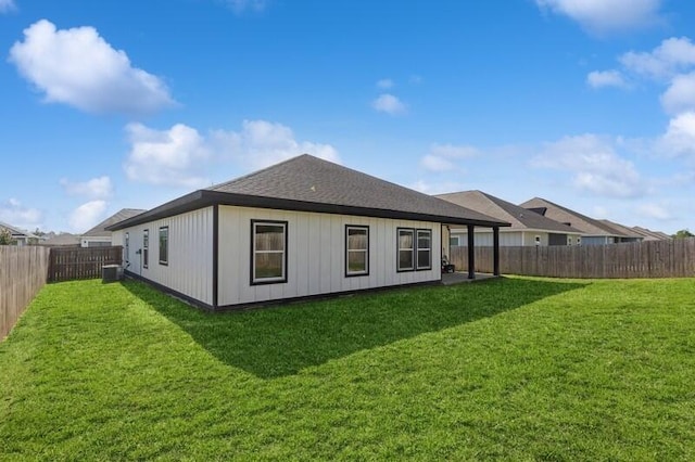 rear view of property featuring a yard and central AC unit