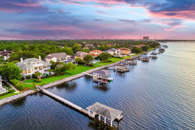 aerial view at dusk featuring a water view