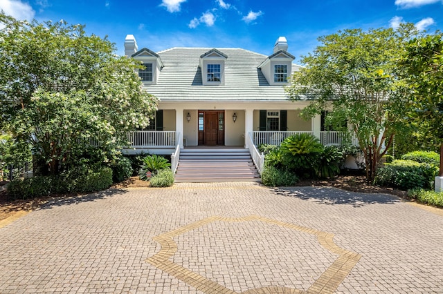 cape cod home featuring a porch