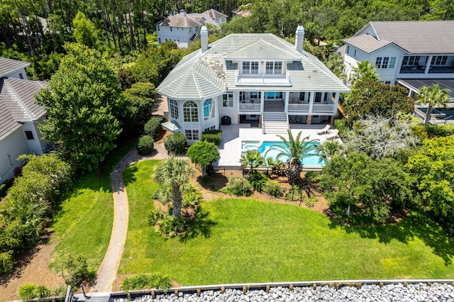 back of property featuring a balcony and a lawn