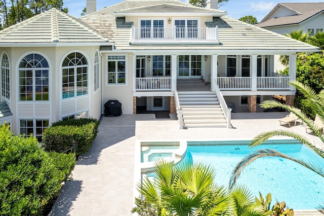 rear view of house with a patio and a balcony