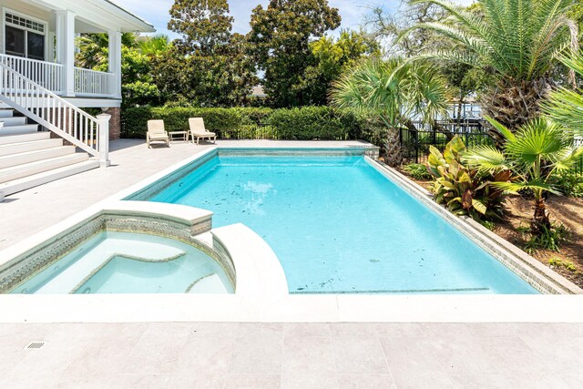 view of pool featuring a patio and an in ground hot tub