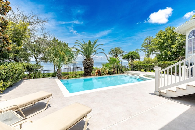 view of pool featuring a water view and a patio area