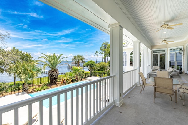 balcony with a water view and ceiling fan