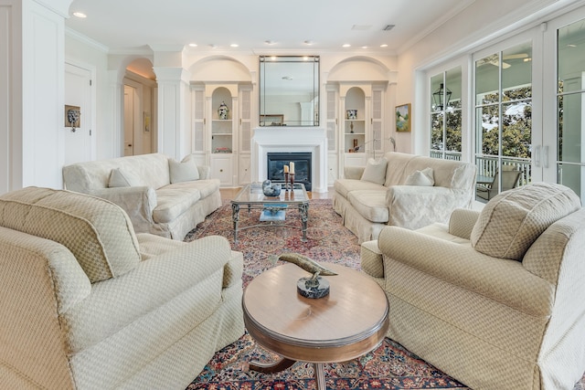 living room featuring ornate columns and crown molding