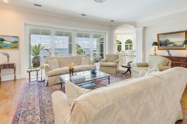 living room featuring ornamental molding, decorative columns, and light hardwood / wood-style flooring