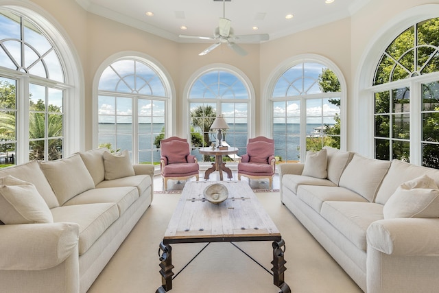 sunroom with a water view and ceiling fan