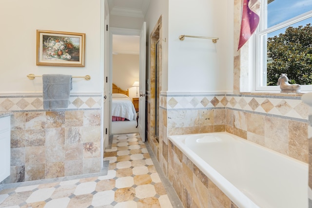 bathroom with tile walls, ornamental molding, and tiled bath