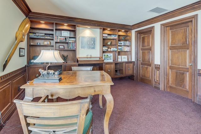 office with built in shelves, crown molding, and dark carpet