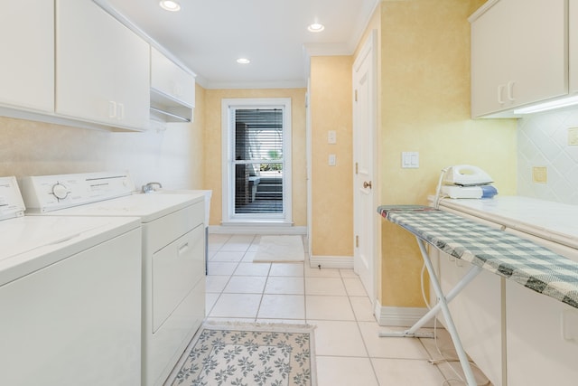 laundry room featuring light tile patterned floors, ornamental molding, washing machine and dryer, and cabinets