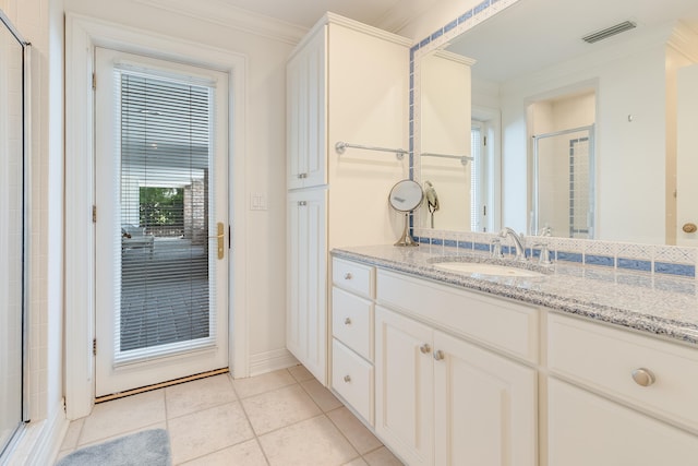 bathroom featuring tile patterned floors, ornamental molding, an enclosed shower, and vanity