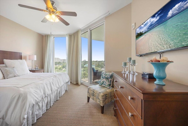 bedroom with ceiling fan, a wall of windows, light carpet, and access to outside