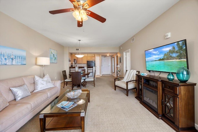 carpeted living room featuring ceiling fan