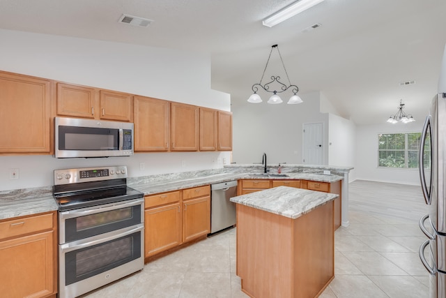 kitchen with a kitchen island, appliances with stainless steel finishes, an inviting chandelier, vaulted ceiling, and sink