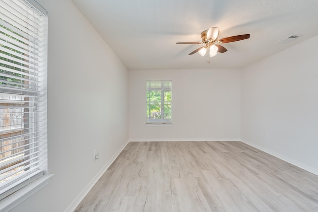 spare room featuring a textured ceiling, light wood-type flooring, and ceiling fan