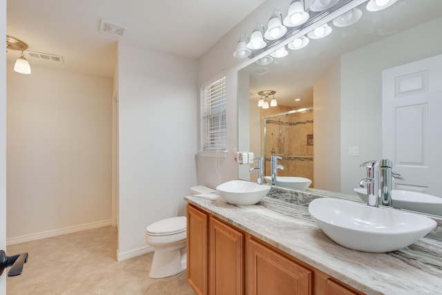 bathroom with vanity, toilet, tile patterned floors, and a shower with door