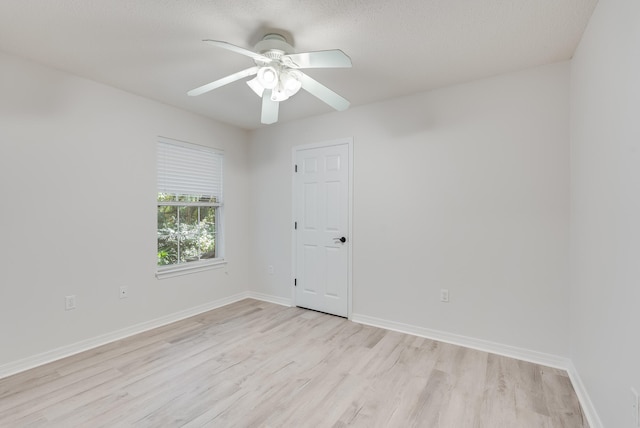 spare room with a textured ceiling, light wood-type flooring, and ceiling fan